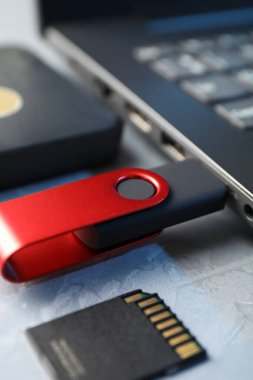 Dizüstü bilgisayara, SD hafıza kartına ve gri desenli tablodaki harici sabit diske bağlı flaş bellek.