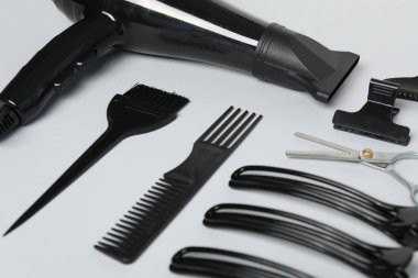 Beyaz arkaplanda farklı saç şekillendirme araçları, yakın plan