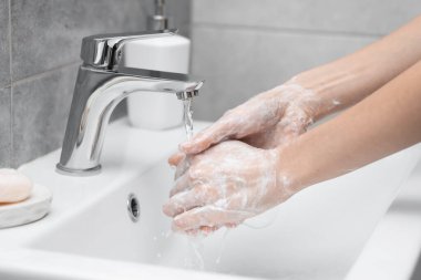 Lavaboda ellerini yıkayan kadın, yakın plan.