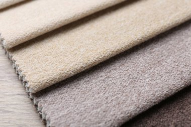 Tahta masadaki farklı kumaşlardan örnekler, yakın plan.