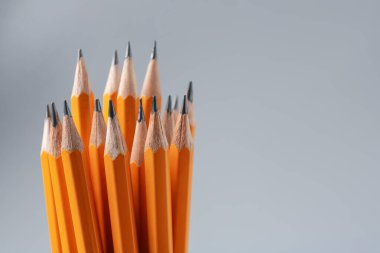 Gri arka planda keskin grafit kalemler, yakın plan. Metin için boşluk