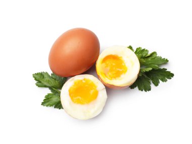 Beyaz arka planda kaynamış yumurta ve maydanoz.