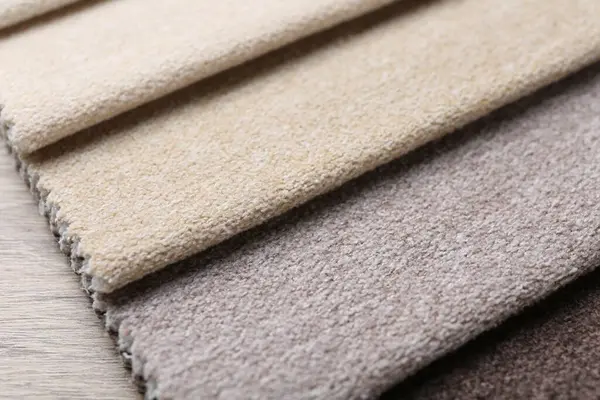 Tahta masadaki farklı kumaşlardan örnekler, yakın plan.