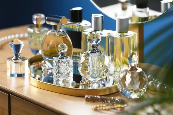 İçerideki ahşap masada parfüm şişeleri.