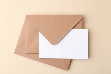 Bej arka planda boş tebrik kartı ve zarflar, üst görünüm