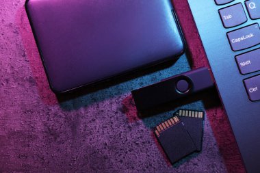SD hafıza kartları, USB flash disk, sabit disk ve koyu gri masadaki dizüstü bilgisayar, düz konum