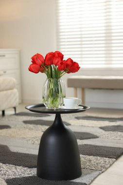 Vazoda güzel kırmızı laleler ve kapalı masada çay.