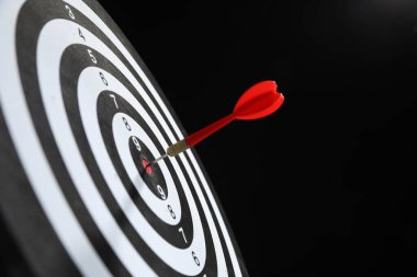 Hedef alınıyor. Siyah arkaplanda ok olan dart tahtası, yakın plan