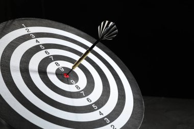 Hedef alınıyor. Karanlık arkaplanda ok olan dart tahtası, yakın plan