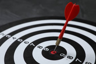 Hedef alınıyor. Gri arkaplanlı oklu dart tahtası, yakın plan