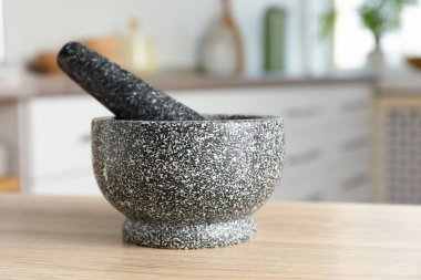 Mutfaktaki ahşap masada taş havan ve tokmak.