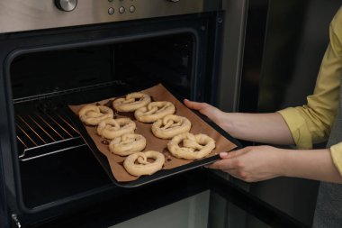 Pişmemiş krakerlerle fırına yemek koyan kadın, yakın plan.