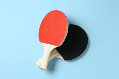 Açık mavi zemin üzerinde pinpon raketleri, düz yatıyordu