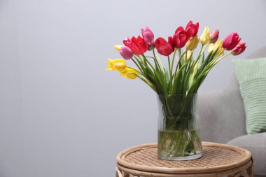 Kapalı alandaki rattan masa üzerinde güzel laleler. Metin için boşluk