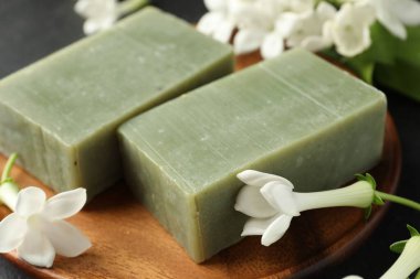 Siyah masada sabun ve yasemin çiçekleri, yakın plan.