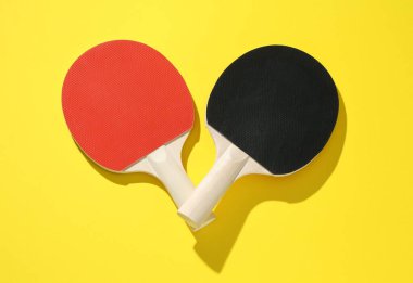 Sarı zemin üzerinde pinpon raketleri, üst görünüm