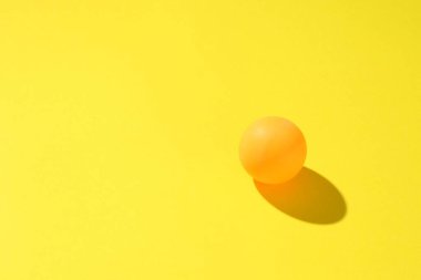 Sarı arka planda bir ping pong topu. Metin için boşluk