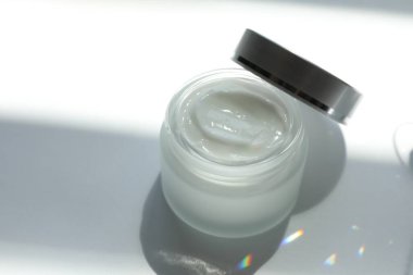 Beyaz arka planda vücut kremi kavanozu, yakın plan.