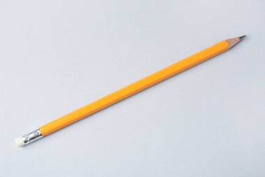 Gri arkaplanda keskin bir grafit kalem, üst görünümde.