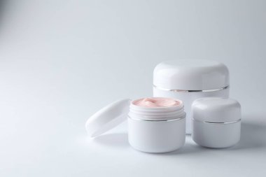 Beyaz arka planda nemlendirici vücut kremi kavanozları