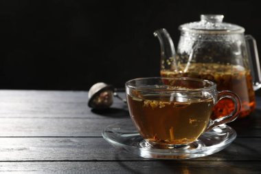 Siyah ahşap masada taze bitki çayı, yakın plan. Metin için boşluk