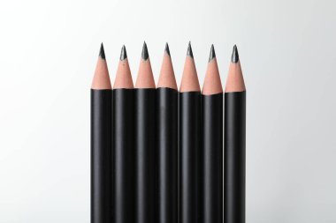 Beyaz arkaplanda birçok keskin grafit kalem, yakın plan