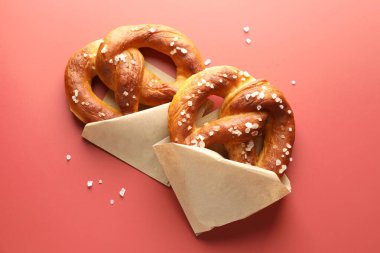 Kırmızı zemin üzerinde tuz bulunan lezzetli krakerler, düz uzanmış.