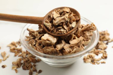 Kuru hindiba kökleri kasede ve kaşıklar beyaz masada, yakın plan.