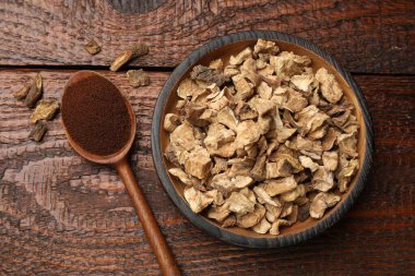 Kuru hindiba kökleri kase ve kaşık içinde, tahta masa üzerinde toz, düz yatıyordu.