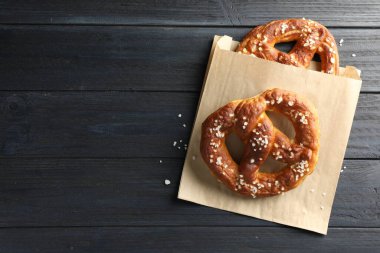 Koyu ahşap masada tuzlu krakerler, üst manzara. Metin için boşluk