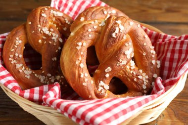 Hasır sepetteki tuzlu krakerler ahşap masada, yakın plan.