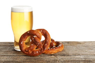 Lezzetli krakerler ve beyaz arka plandaki ahşap masada bir bardak bira. Metin için boşluk