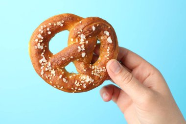 Açık mavi arka planda lezzetli krakerli kadın, yakın plan.