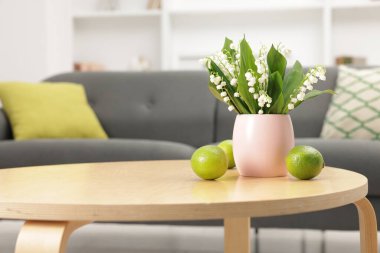 Bir buket güzel vadi zambağı ve kahve masasında limon.