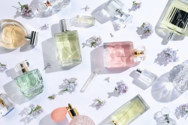 Lüks parfümler ve beyaz arka planda güzel leylak çiçekleri.