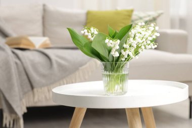 Bir buket güzel vadi zambağı kahve masasının üstünde.