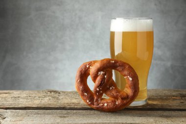 Lezzetli kraker ve bir bardak bira ahşap masada, arka planda gri, yakın plan. Metin için boşluk