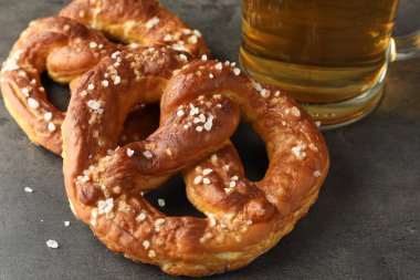 Lezzetli krakerler ve koyu dokulu masada bir bardak bira, yakın plan.