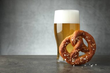 Lezzetli kraker ve koyu dokulu masada bir bardak bira. Gri arka planda, yakın plan. Metin için boşluk