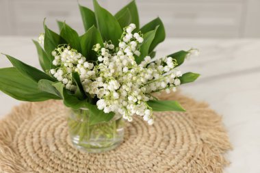 Vadinin güzel zambaklarından oluşan bir buket beyaz masa içinde, yakın plan.