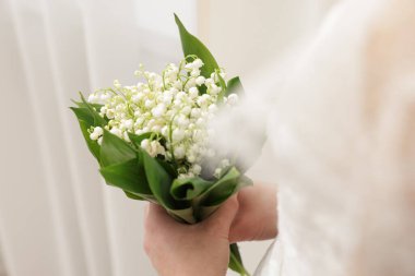 İçinde güzel vadi zambakları olan gelin, yakın plan.