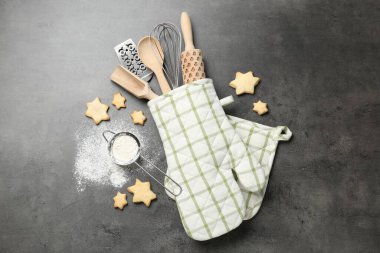 Farklı mutfak aletleri fırın eldiveninde, un ve kurabiyeler gri masada, düz yerde.