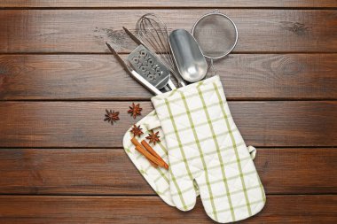 Farklı mutfak aletleri fırın eldiveni, tarçın ve anason yıldızları ahşap masa, düz yatıyordu.