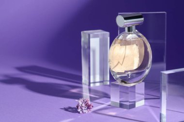 Mor arka planda parfüm şişesi ve leylak çiçeklerinin şık sunumu, yakın plan. Metin için boşluk