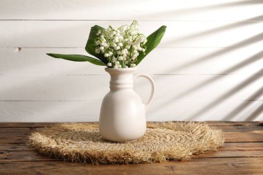 Vadinin güzel zambakları vazoda, ahşap masada.