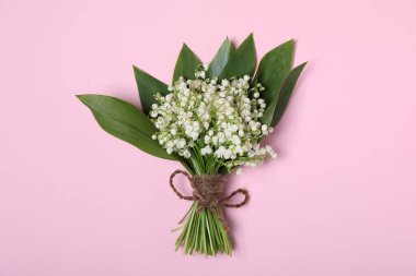 Açık pembe arka planda, vadideki güzel zambak çiçekleri.