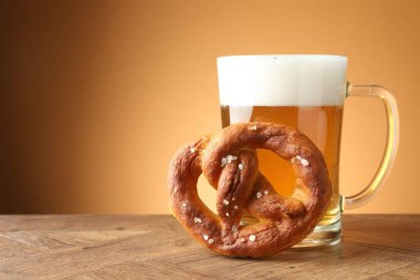 Lezzetli kraker ve ahşap masada cam bardak bej renkli arka planda, yakın plan. Metin için boşluk