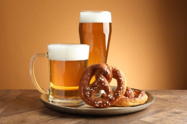 Lezzetli krakerler ve bira ahşap masada altın eğimli arka planda, yakın plan