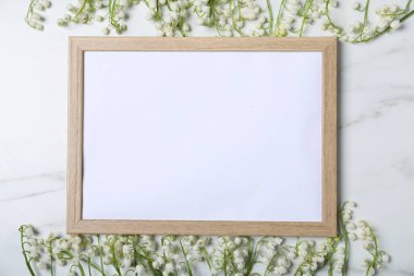 Vadideki güzel zambak çiçekleri ve beyaz mermer arka planda boş bir çerçeve. Metin için boşluk