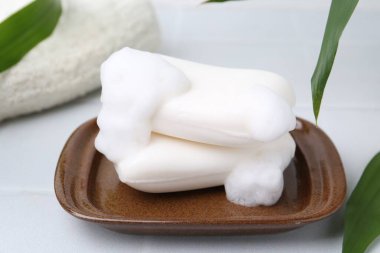 Beyaz masadaki köpüklü sabun çubukları, yakın plan.